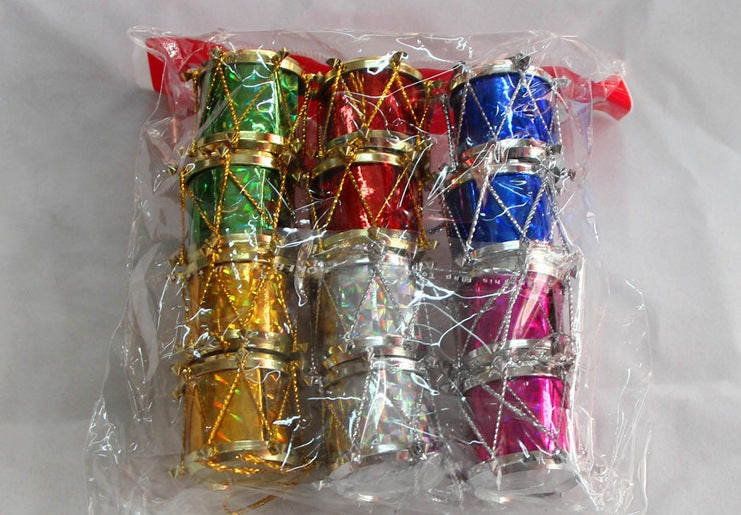 A clear plastic bag contains colorful miniature drums in green, red, blue, gold, silver, and pink, decorated with gold accents, arranged in four neat columns.