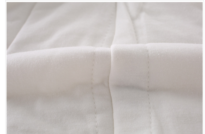 Close-up of a white fabric with visible stitching and a neat seam. The material appears soft and smooth, showcasing professional tailoring and minimalistic design.