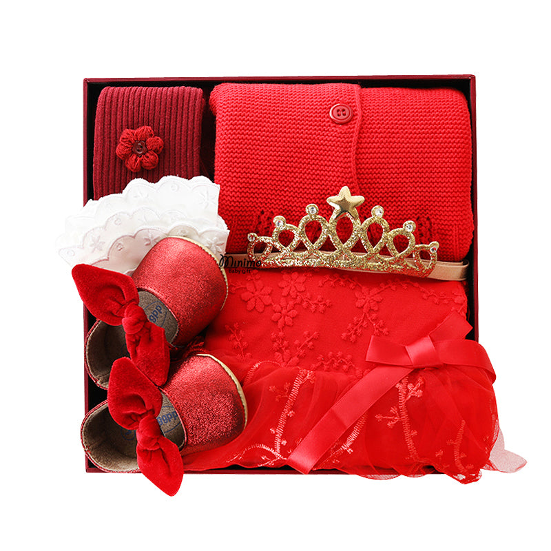 Box set with red knit sweater, floral crown, ruffled lace, glitter shoes with bows, and patterned dress, all in vibrant red with gold accents.