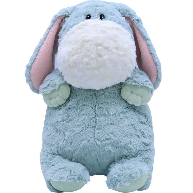 A plush toy resembling a chubby dog with light blue fur, floppy ears with pink lining, a large white snout, small black eyes, and round mint green paws, sitting upright.