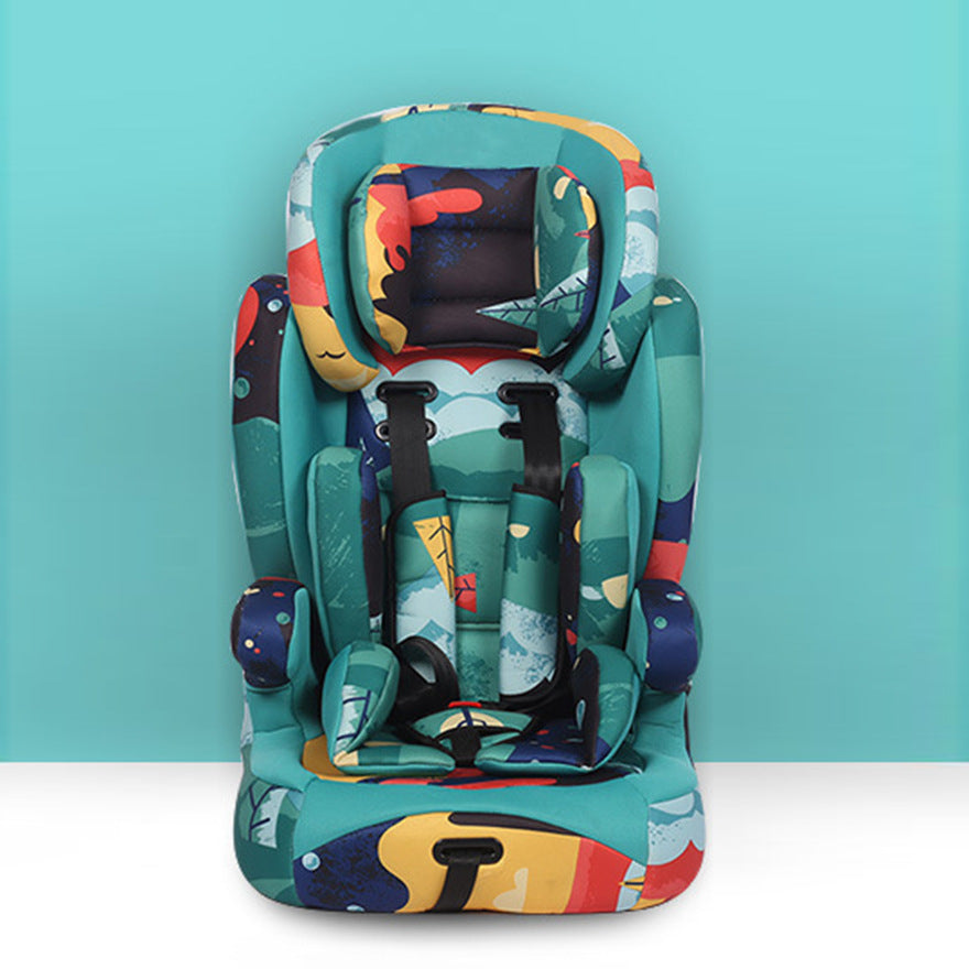 Colorful, multi-patterned child car seat against a turquoise background, featuring abstract and nature-inspired designs, with adjustable black safety harnesses.