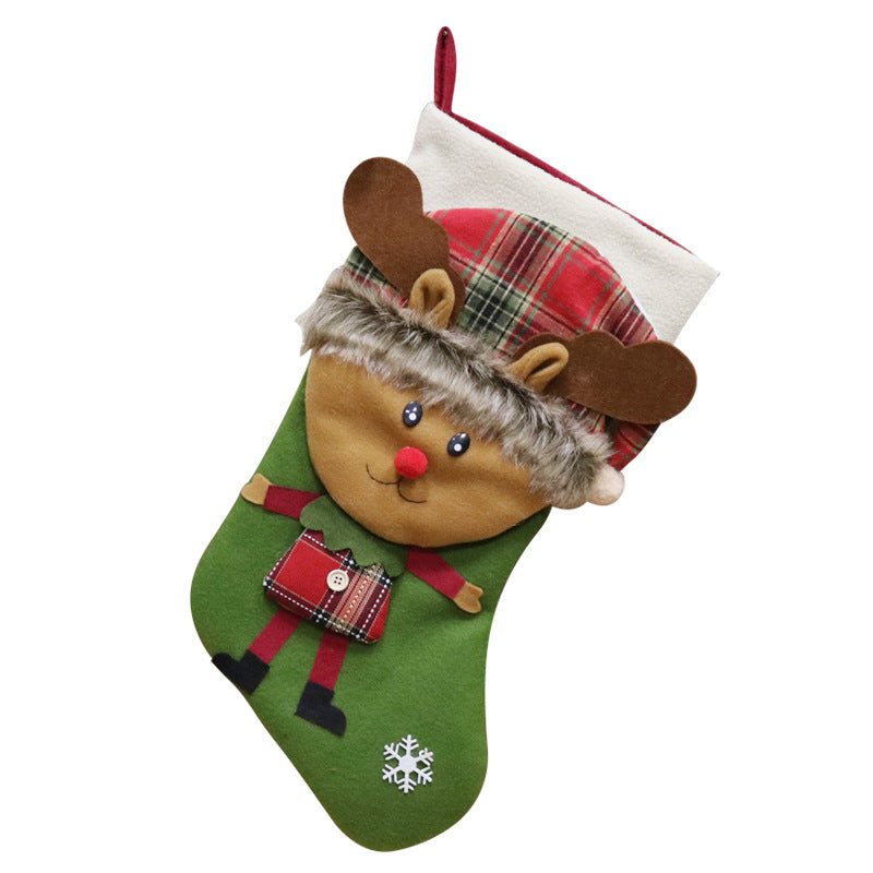 Green Christmas stocking featuring a plush reindeer with a plaid hat and a red nose, holding a gift. Decorated with a snowflake design and a red hanging loop at the top.