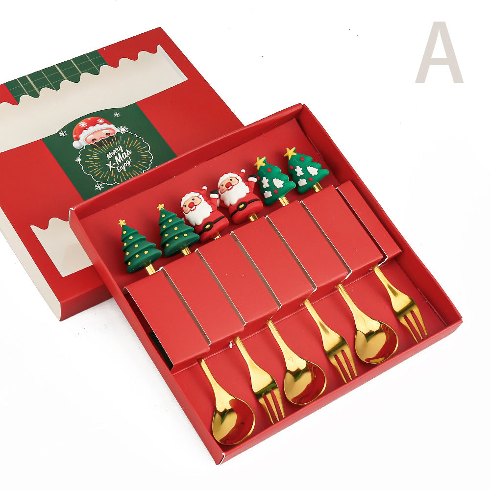 Red gift box with festive cutlery: gold spoons and forks, topped with Santa and Christmas tree handles. Box lid features a "Merry Xmas" greeting with Santa graphic.