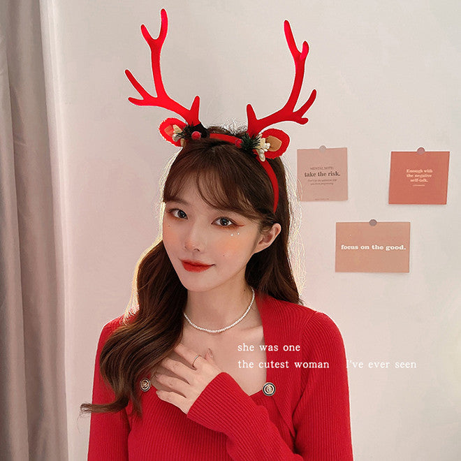 Woman in a red top wears reindeer antler headband, posing indoors. Background has motivational quote cards on the wall. Text on image reads, "she was one of the cutest woman I've ever seen."