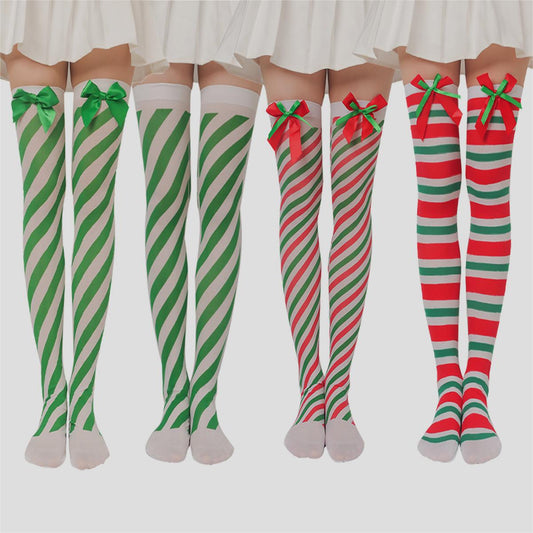 Four pairs of legs wearing thigh-high striped stockings with holiday colors. Two pairs of green and white, one red and white with bows, and one red and green with bows.