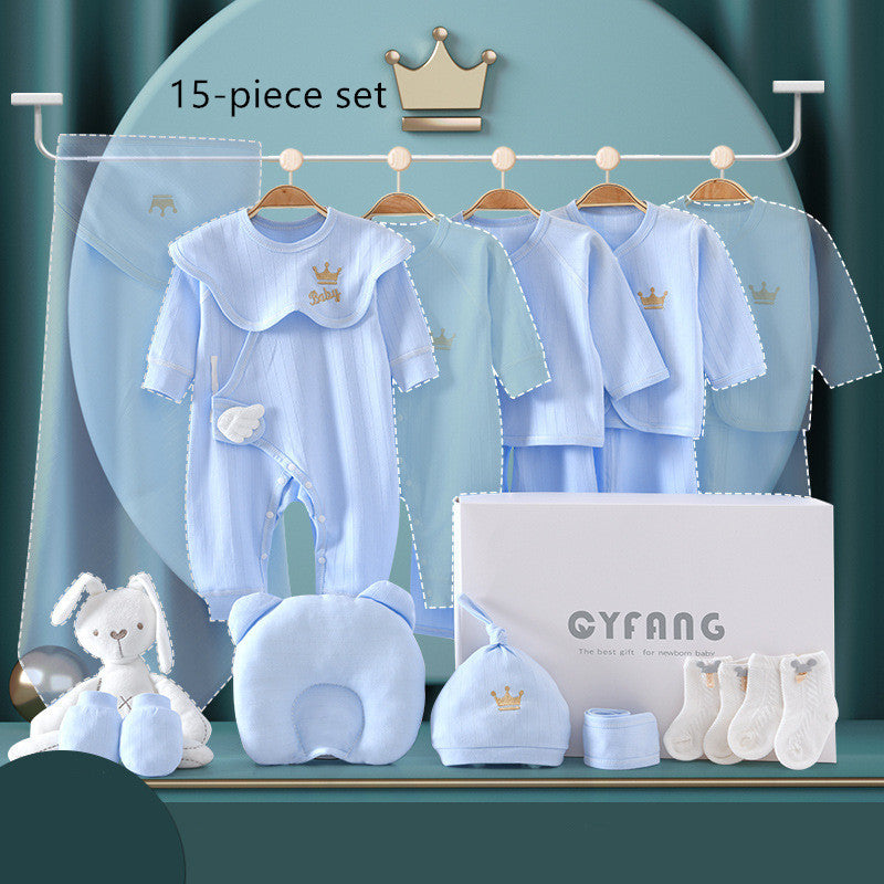 15-piece baby gift set in soft blue displayed. Includes bodysuits, hats, socks, a plush toy, mittens, pillow, and box, all featuring a crown motif.