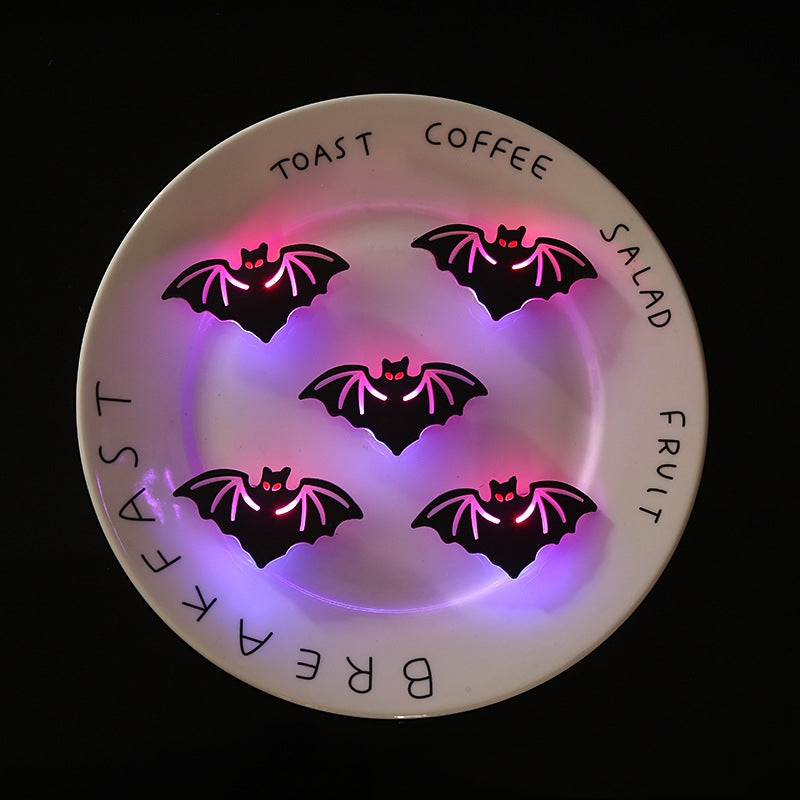 A white plate with words "TOAST", "COFFEE", "SALAD", "FRUIT", "BREAKFAST" has five glowing black bat shapes with pink and purple lighting, arranged in a circular pattern.