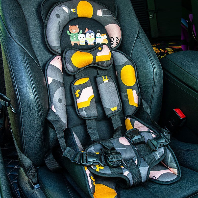 A colorful child car safety seat with animal designs and abstract patterns in yellow, black, and pink sits securely in a black car interior.