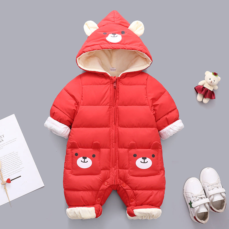 Red baby snowsuit with bear face on hood and pockets. Soft white lining, accompanied by white shoes, a teddy bear toy, and a paper with text on a gray background.