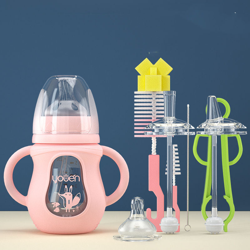 Pink baby bottle with two handles and transparent lid, accompanied by various cleaning brushes and accessories, set against a blue and beige background.