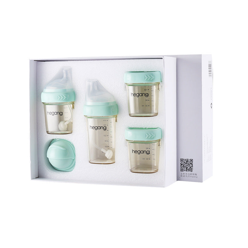 Set of baby feeding bottles and containers with teal lids in a white box. The bottles have measurement markings and feature a simplistic design, with extra lids included.