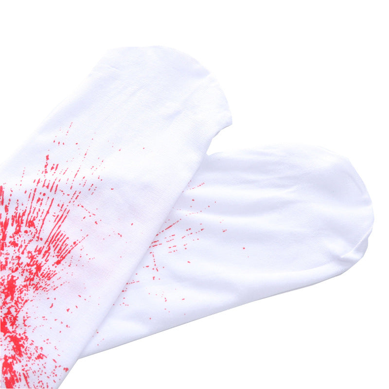 White socks with red paint splatter design on the left sock, placed on a plain background.