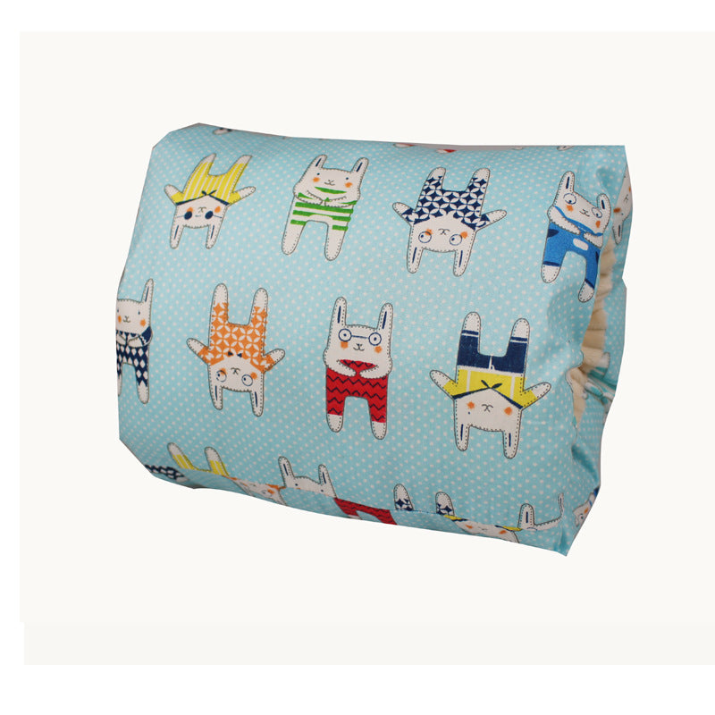 Light blue pillow with a pattern of cartoon rabbits wearing colorful outfits. The fabric background features white polka dots, creating a playful and whimsical design.