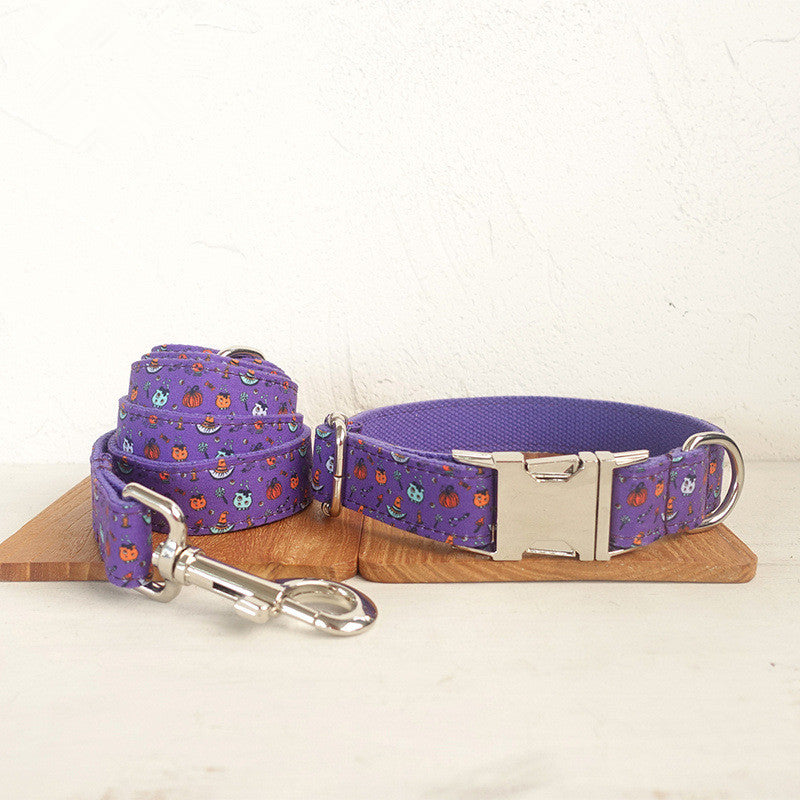 Purple dog collar and leash set with playful Halloween-themed prints, featuring pumpkins and bats. Includes metal buckle and clip, displayed on a wooden surface.