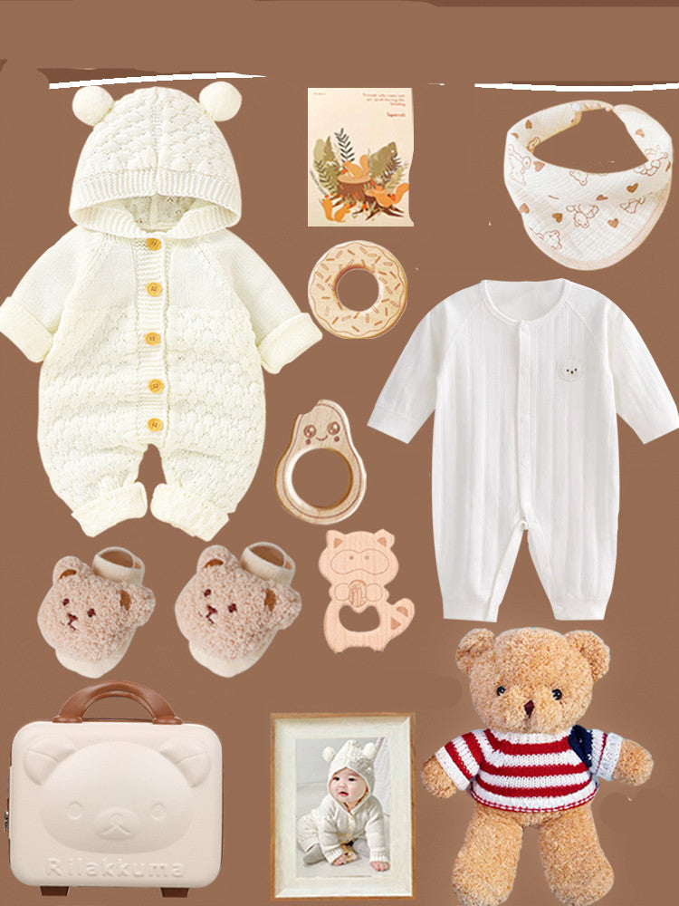 Baby gift set on brown background featuring a knit bear onesie, two bibs, white sleeper, plush bear, baby photo, Rilakkuma case, bear booties, and teething toys.