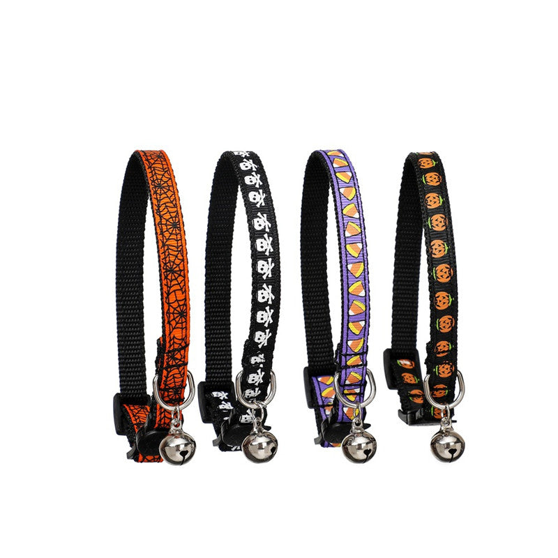 Four Halloween-themed cat collars, each with a bell. Designs include spiderwebs, skulls, candy corn, and jack-o'-lanterns in orange, black, and purple colors.