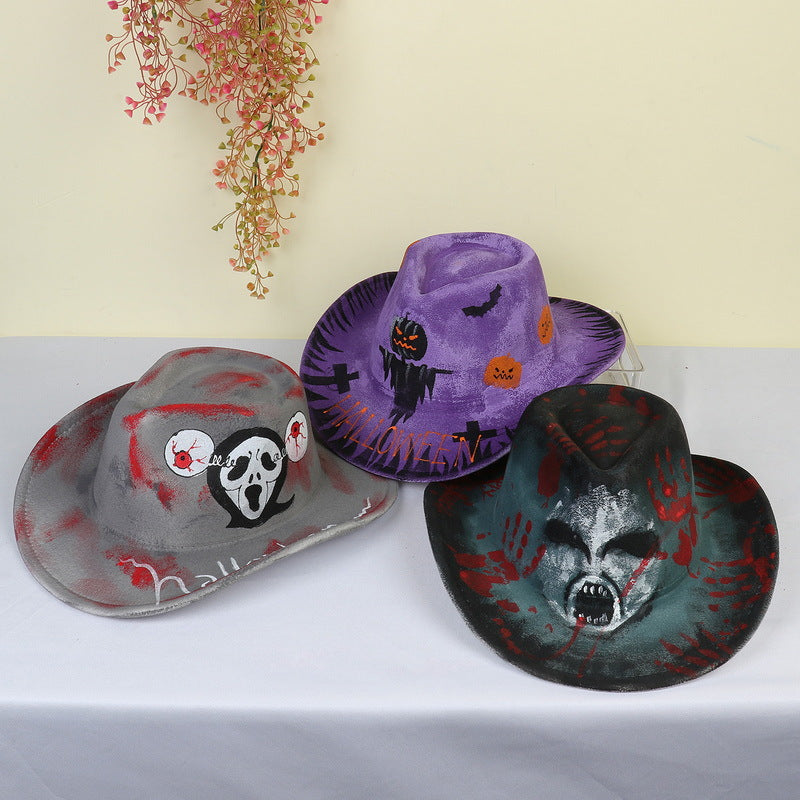 Three Halloween-themed cowboy hats on a table: a gray hat with a skull, a purple hat with pumpkins and bats, and a green hat with a screaming face. Pink flowers hang above.