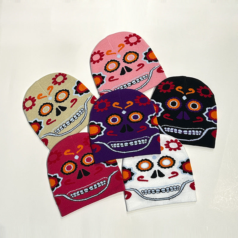 Five beanies display colorful sugar skull designs, each with distinct patterns and hues: beige, pink, black, purple, and white. The skulls feature vibrant floral and geometric motifs.
