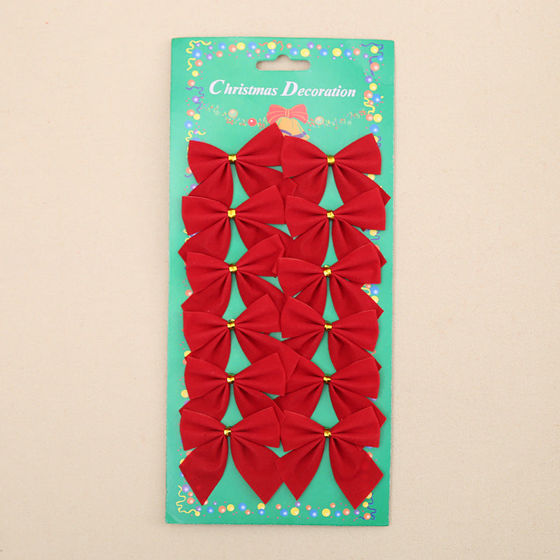 Pack of 12 small red Christmas bows with gold centers displayed on a festive green cardboard labeled “Christmas Decoration” with colorful border accents.