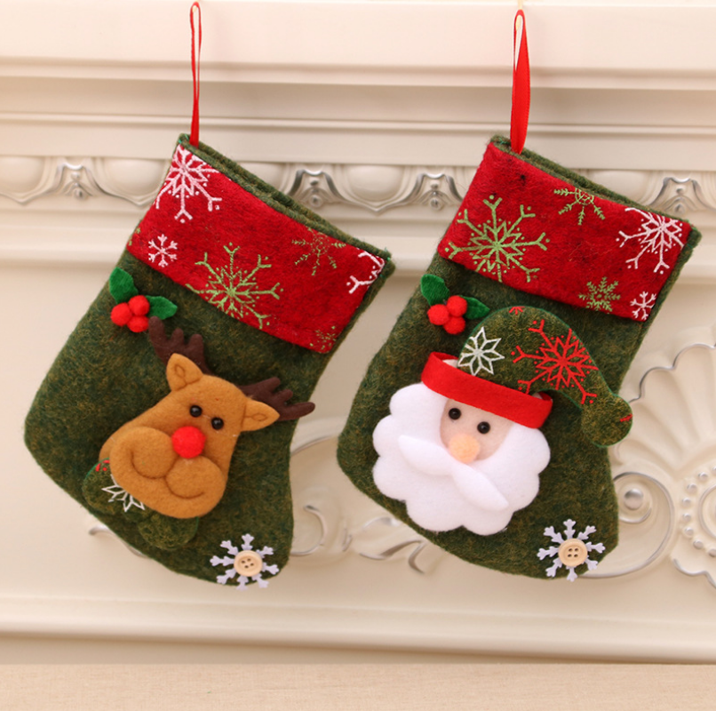 Two festive Christmas stockings with red tops hang side by side. One has a reindeer design, the other features Santa Claus. Both are adorned with snowflakes and holly.