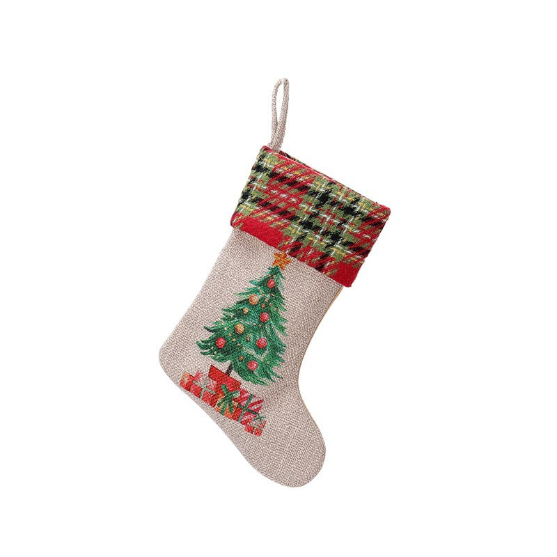 Burlap Christmas stocking with a plaid cuff, featuring a decorated tree and presents design on the front.