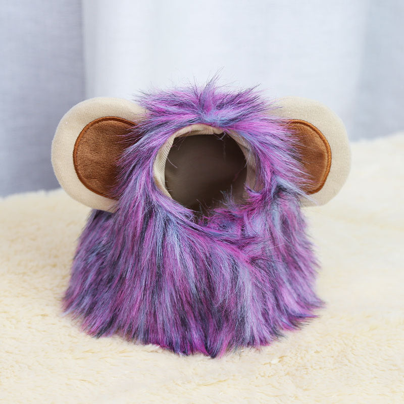 Plush animal costume with purple and blue fur, featuring large beige and brown ears, displayed on a soft cream surface against a neutral background.