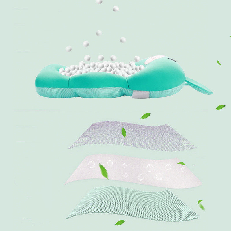 Turquoise ergonomic baby head pillow with white filling, surrounded by green leaves. Three layers below show its breathable material and design features on a light green background.