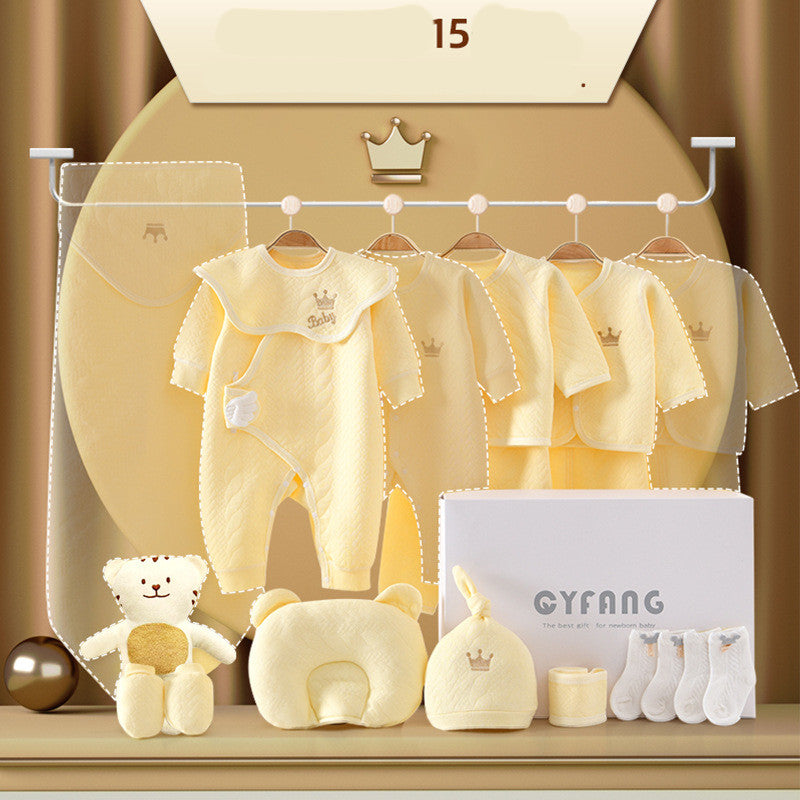 Yellow baby clothing set includes a blanket, onesies, jackets, hat, socks, and plush toys with crown motifs. Displayed on a rack with a box labeled "GYFANG."