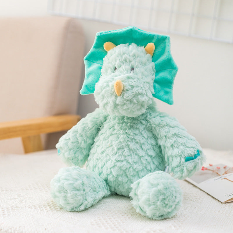 Soft, mint green stuffed dinosaur toy with contrasting teal frill and small orange horns sits on a textured white surface, with a chair and wall grid in the background.