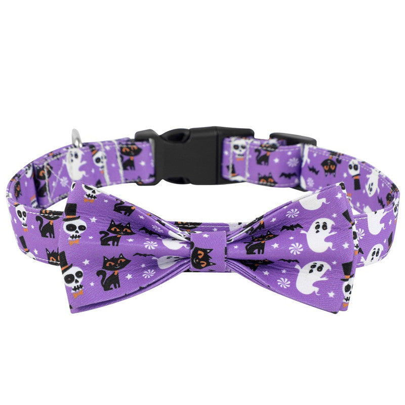 Purple pet collar with bow tie, featuring cute Halloween designs of black cats, skulls, and ghosts. The collar has an adjustable black buckle.