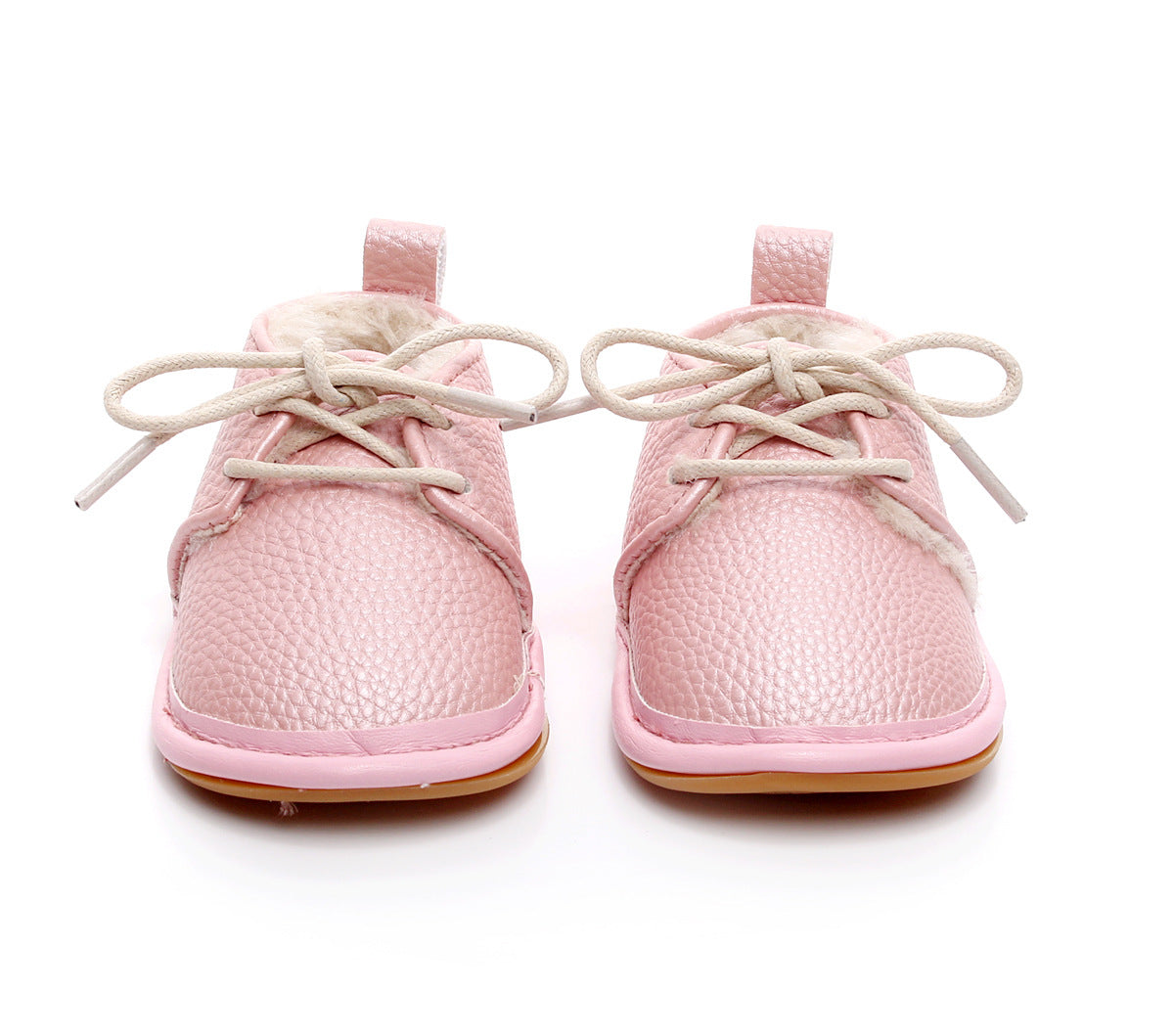 Soft pink baby shoes with textured material, lace-up closure, and a cozy lining, displayed on a white background. The soles are a light tan color.