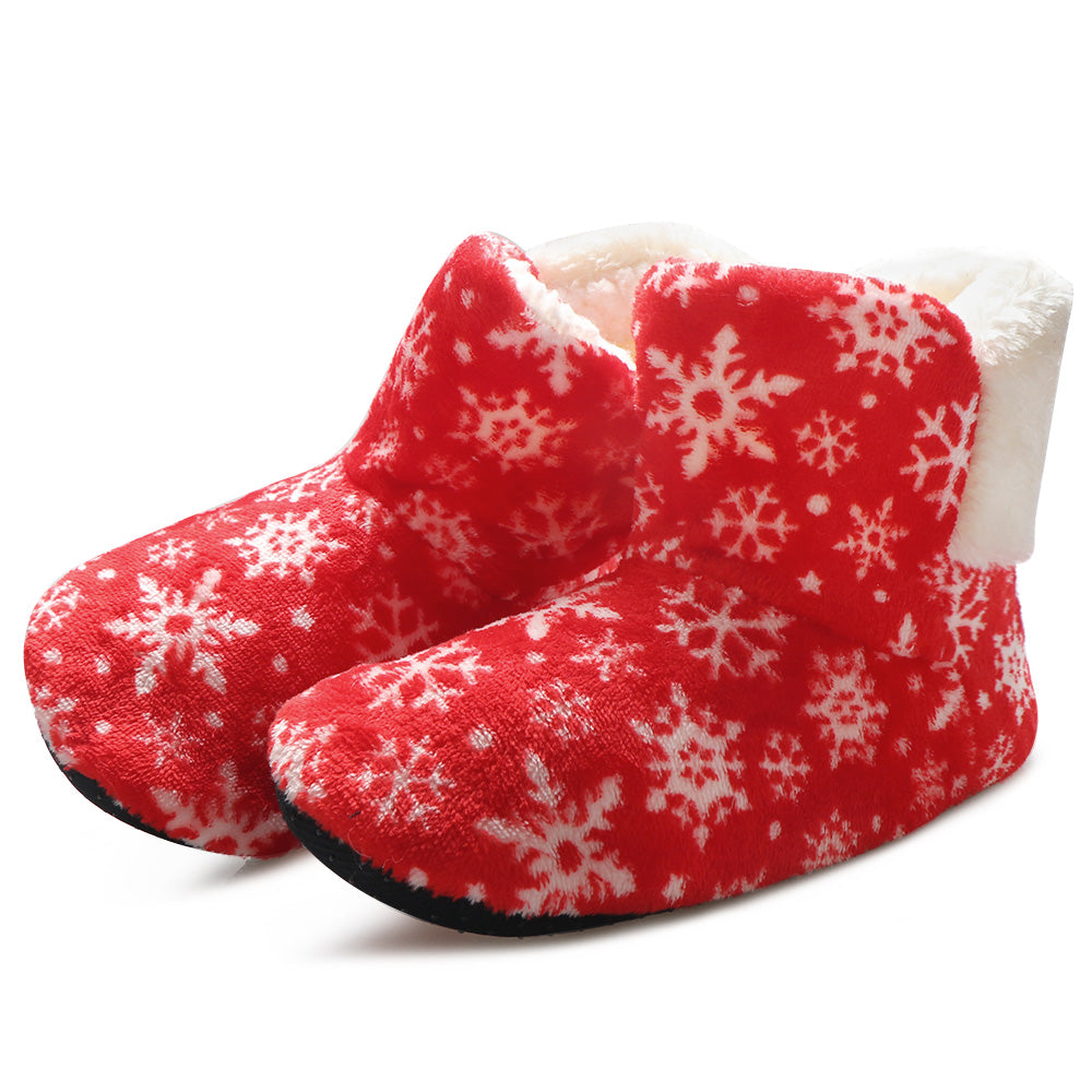 Red plush slippers with a soft white interior are adorned with white snowflake patterns. The slippers have a cozy, ankle-high design with a black sole, ideal for winter warmth.