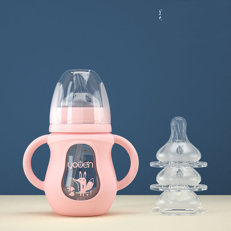 Pink baby training cup with handles and a fox design, alongside a stack of three clear baby bottle nipples on a beige surface against a blue background.