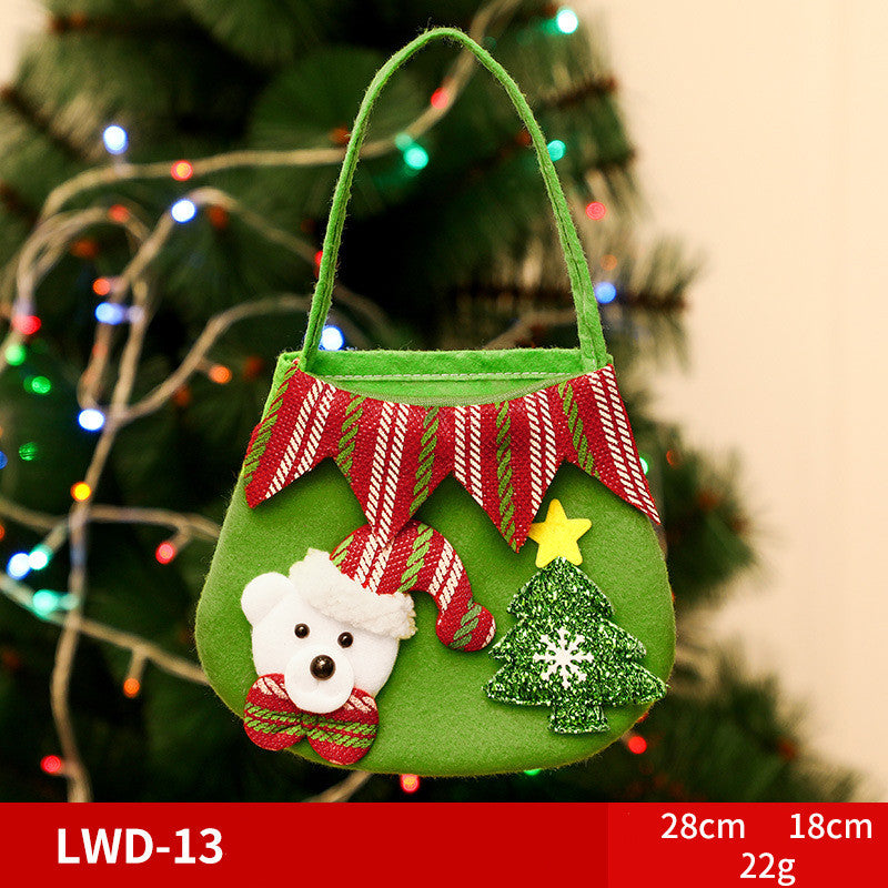 Green felt Christmas bag with red striped trim, featuring a white bear in a Santa hat and a glittery green tree with a yellow star. Background of a decorated tree.