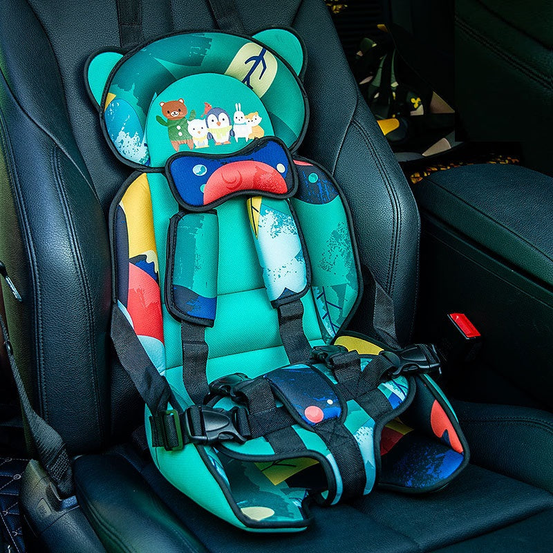 Colorful child car seat with cartoon animal characters on a vibrant teal background, featuring black safety straps and buckles, installed in a black car interior.