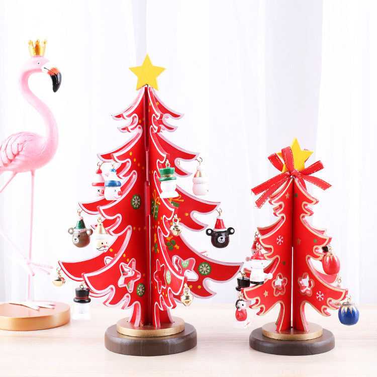 Two red decorative Christmas trees with star toppers and ornaments stand on a table. A pink flamingo figurine with a golden crown is visible in the background.