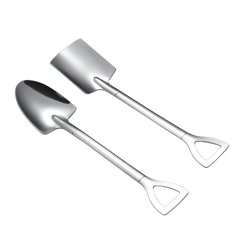 Two silver spoon and spade-shaped utensils with handles resembling shovel grips, placed side by side on a white background.