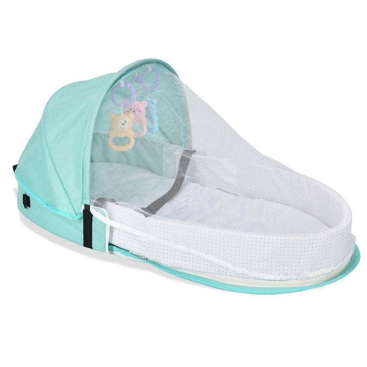 Portable baby bed with a turquoise canopy and white mesh cover, featuring hanging toys—a teddy bear, elephant, and rabbit. The bed has a secure, cozy sleeping area.