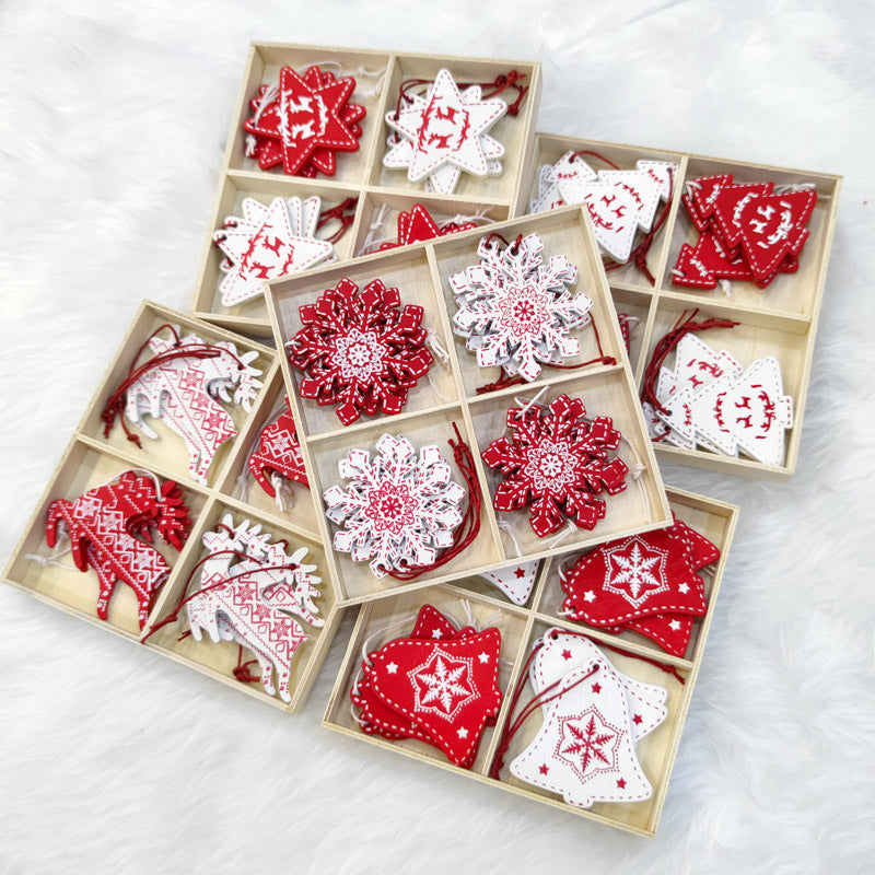 Wooden boxes filled with red and white Christmas ornaments featuring patterns of stars, snowflakes, reindeer, and bells, laid out on a fluffy white background.