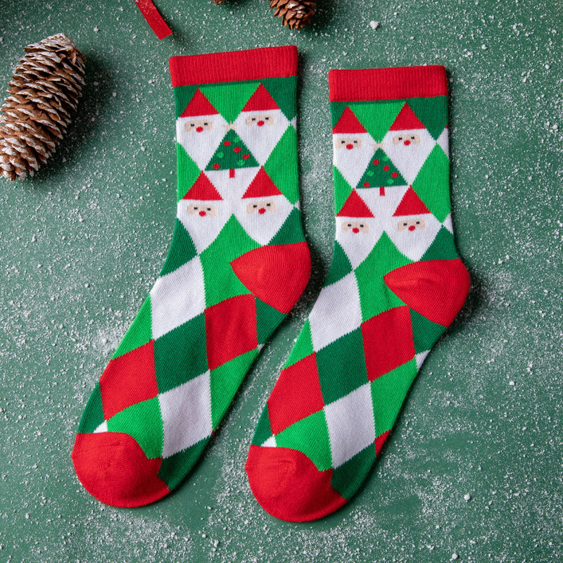 Festive socks with red toes and tops feature Santa and Christmas tree patterns on a green, red, and white diamond design. Pinecones and snow-like background enhance the holiday theme.