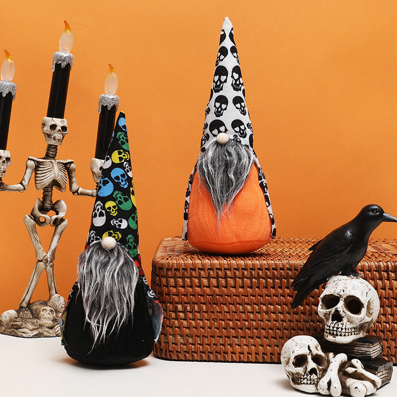 Two Halloween-themed gnomes with skull-patterned hats, one in colorful skulls and the other in black and white, sit by a skeletal candelabra. Decorative skulls and a black raven enhance the spooky ambiance against an orange background.