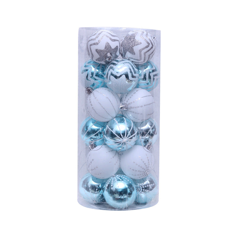 A clear cylindrical container holds assorted blue, silver, and white Christmas ornaments with various patterns, including stars and stripes.