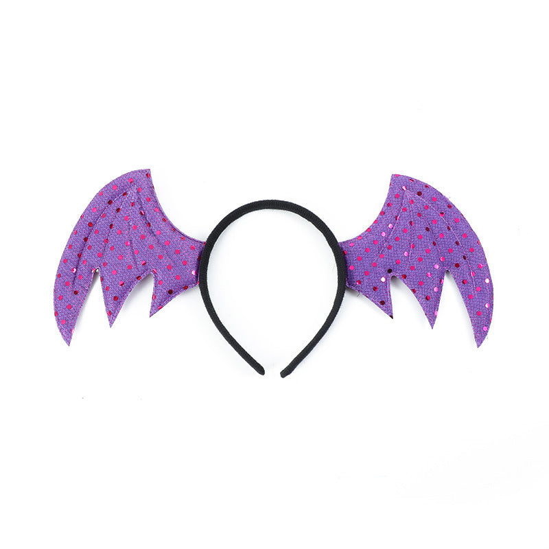 Purple bat wing headband with black band. The wings feature pink polka dots and pointed edges, giving a playful, whimsical look. Ideal for costumes or festive occasions.